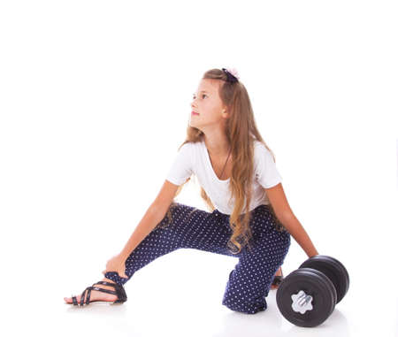 Portrait of little trainer posing in studio with dumbbellsの写真素材