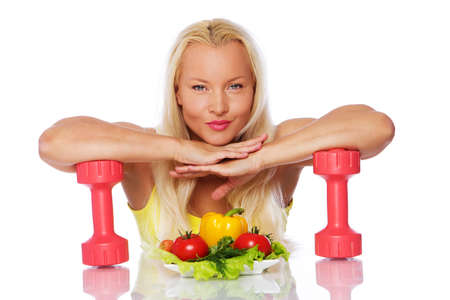 Portrait of sport woman posing in studio with vegetablesの写真素材