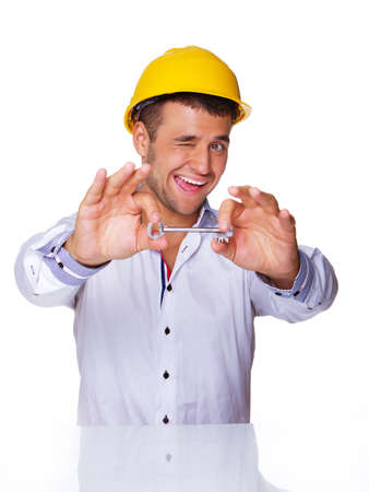 Portrait of smiling engineer posing in studio with key from houseの写真素材