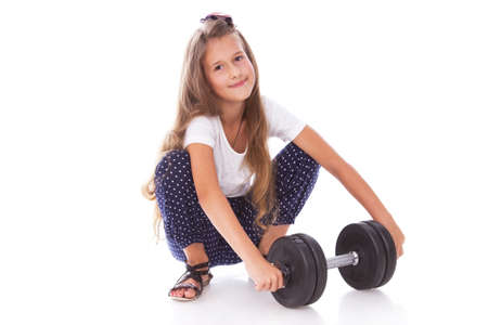 Portrait of little trainer posing in studio with dumbbellsの写真素材