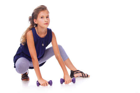 Portrait of little trainer posing in studio with dumbbellsの写真素材
