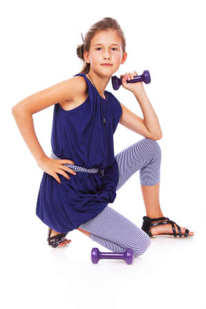 Portrait of little trainer posing in studio with dumbbellsの写真素材