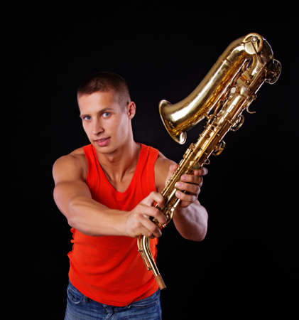 A portrait of a good-looking man swinging his saxophoneの写真素材
