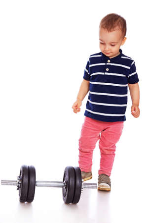 Portrait of little baby going to play with dumbbellsの写真素材