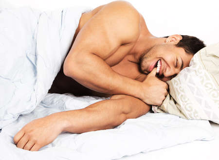 Portrait of a happy man  lying on his bed at home の写真素材