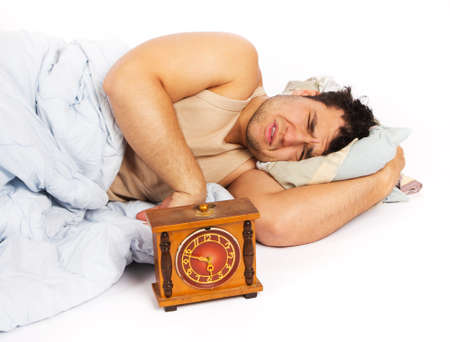 angry man and alarm clock in bedroomの写真素材