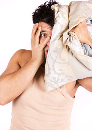 A tired looking man. He is holding a pillow の写真素材