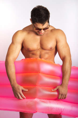 sexy caucasian fit man posing with mattressの写真素材