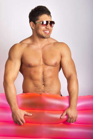 sexy caucasian fit man posing with mattressの写真素材