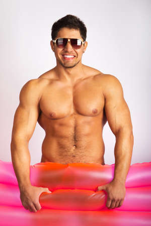 sexy caucasian fit man posing with mattressの写真素材