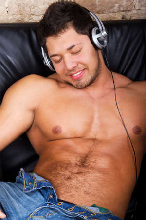 Portrait of a relaxed young guy enjoying music on headphone の写真素材