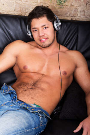 Portrait of a relaxed young guy enjoying music on headphone の写真素材