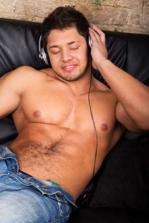 Portrait of a relaxed young guy enjoying music on headphone の写真素材