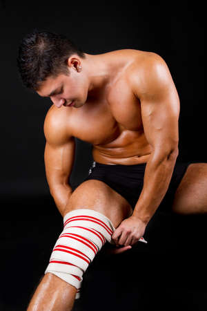 Athlete put bandage on legの写真素材