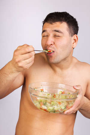 young men eating salad close up shoot の写真素材