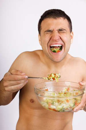 young men eating salad close up shoot の写真素材