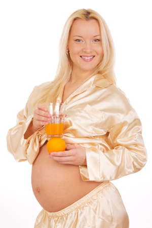 pregnant blonde girl with fresh orangeの写真素材