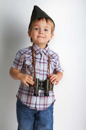 Cute positive boy with binoculars