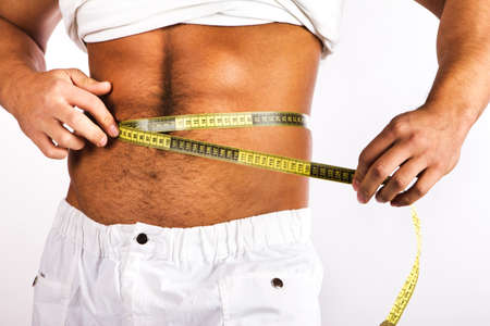 Muscular and tanned man is being measured の写真素材