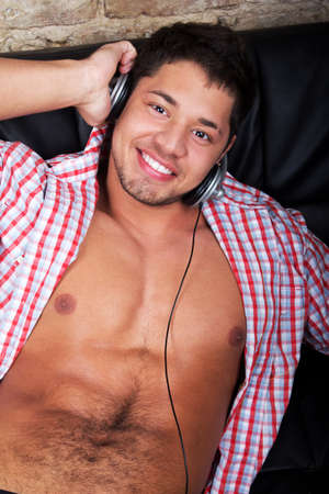 Portrait of a relaxed young guy enjoying music on headphone の写真素材