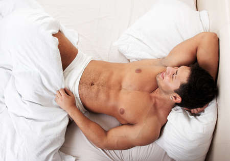 Happy man lying in his bedの写真素材