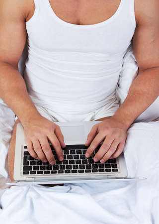 Young man using laptop at the bedtime
の写真素材