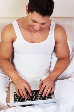 Young man using laptop at the bedtime
の写真素材