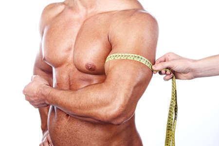 Muscular and tanned man is being measured の写真素材
