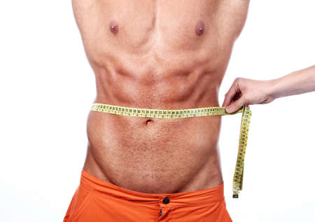 Muscular and tanned man is being measured の写真素材