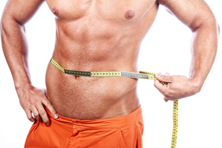 Muscular and tanned man is being measured の写真素材