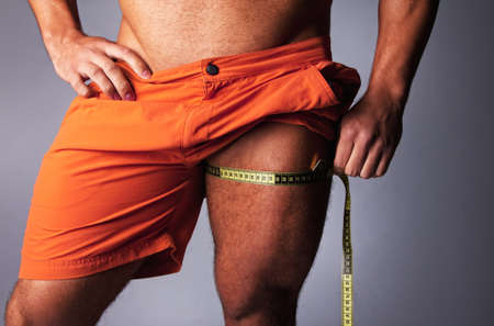 Muscular and tanned man is being measured の写真素材