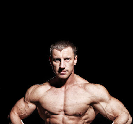Portrait of muscular bodybuilder, isolated on blackの写真素材