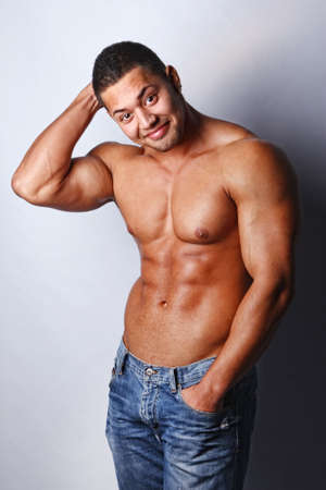 Portrait of a macho man against grey background の写真素材