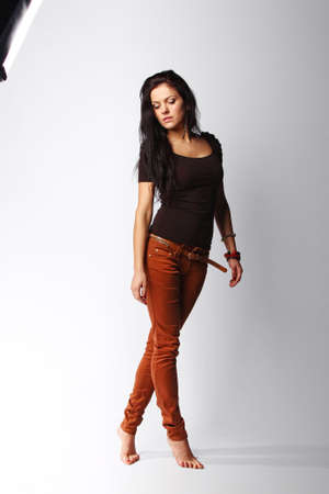 Image of attractive brunette female looking down, isolated on greyの写真素材