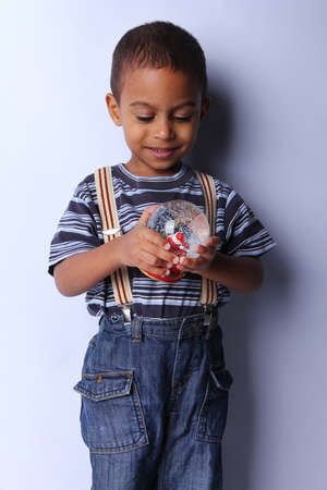 Cute happy 3 year old American-African boy playing with christmas ballの写真素材