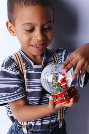 Cute happy 3 year old American-African boy playing with christmas ballの写真素材