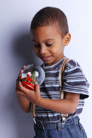 Cute happy 3 year old American-African boy playing with christmas ballの写真素材