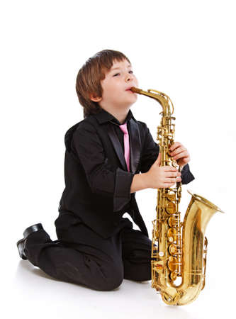 Portrait of young sexy musician posing in studio with saxophoneの写真素材