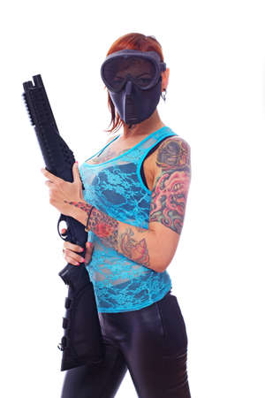 A young masked punk girl is firmly holding her shotgunの写真素材