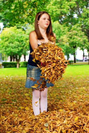 Portrait of little girl playing with leafs outsideの写真素材