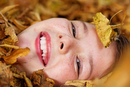 Portrait of little girl playing with leafs outsideの写真素材