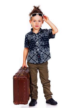 Portrait of young traveler posing in studio with suitcaseの写真素材