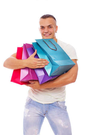 Portrait of sexy man posing in studio with shopping bagsの写真素材