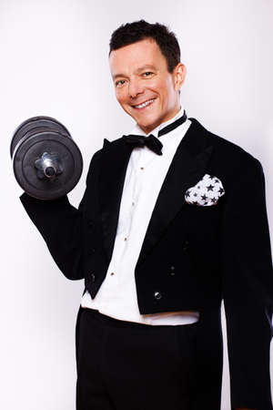 Portrait of man posing in studio in official clothes with dumbbellsの写真素材