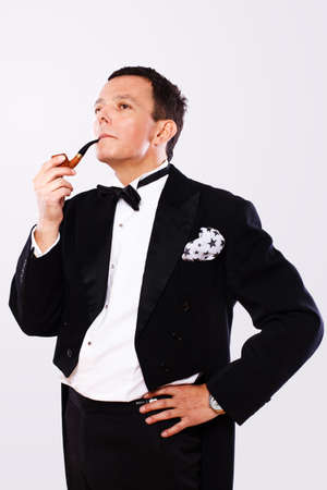 Portrait of man posing in studio in official clothes with pipeの写真素材