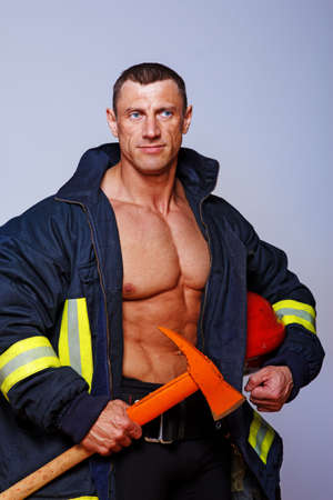 Portrait of muscle fireman posing in studio in uniformの写真素材