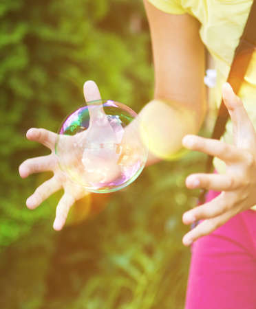 Portrait of kid hands going to catch the buble