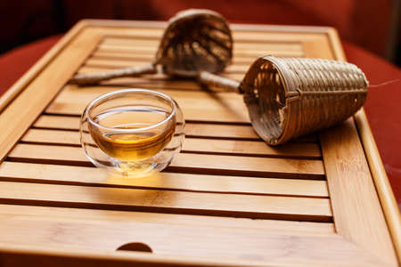 Wooden tray with a teacup and two tea strainersの写真素材