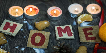 Candles, mandarins, gingerbread surrounding handmade welcoming cards