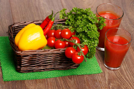 Basket with tomatoes and two glasses of juiceの写真素材